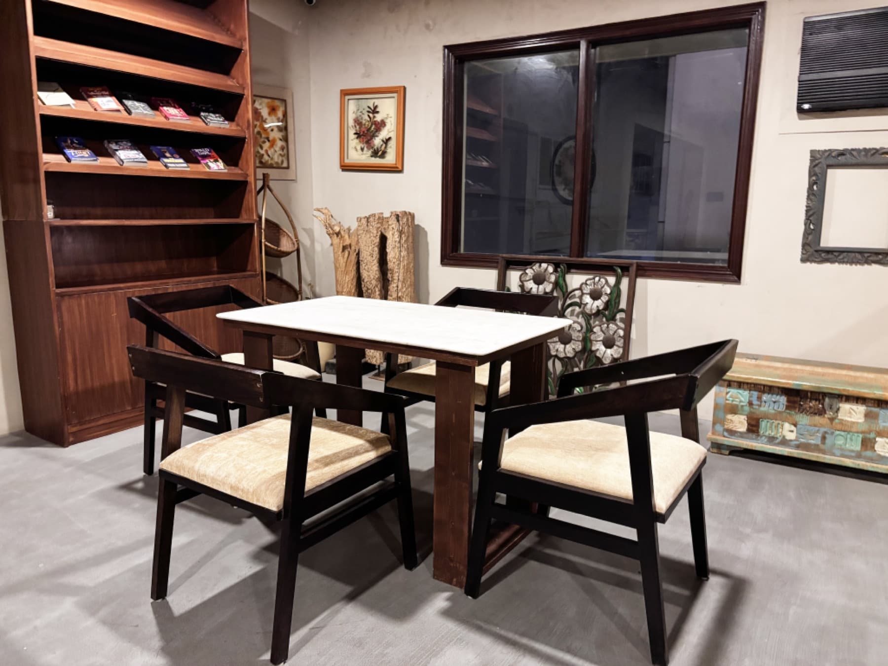 Conversation table set for four with wooden bookcase and artwork